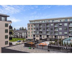 A modern apartment complex with a playground in the courtyard.
