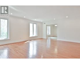 A spacious room with wooden flooring and white walls.
