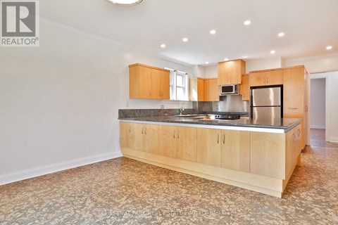 A large kitchen with wooden cabinets and a patterned floor.