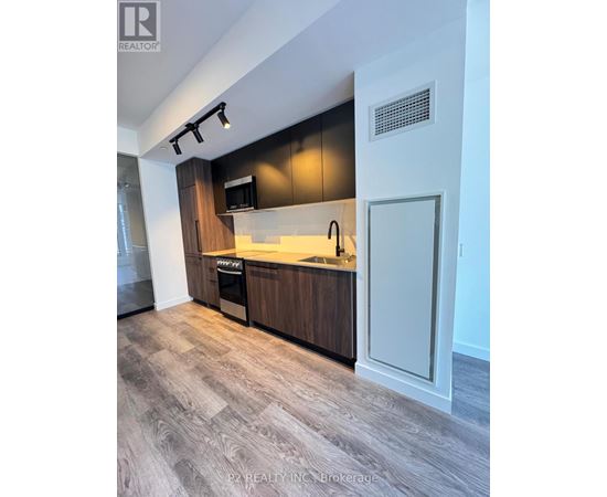 A modern kitchen with dark wood cabinets and a white countertop.