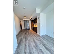 A spacious room with a grey floor and white walls.