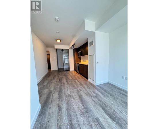 A spacious room with a grey floor and white walls.