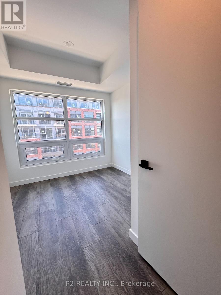 A room with a window showing a view of a building outside.