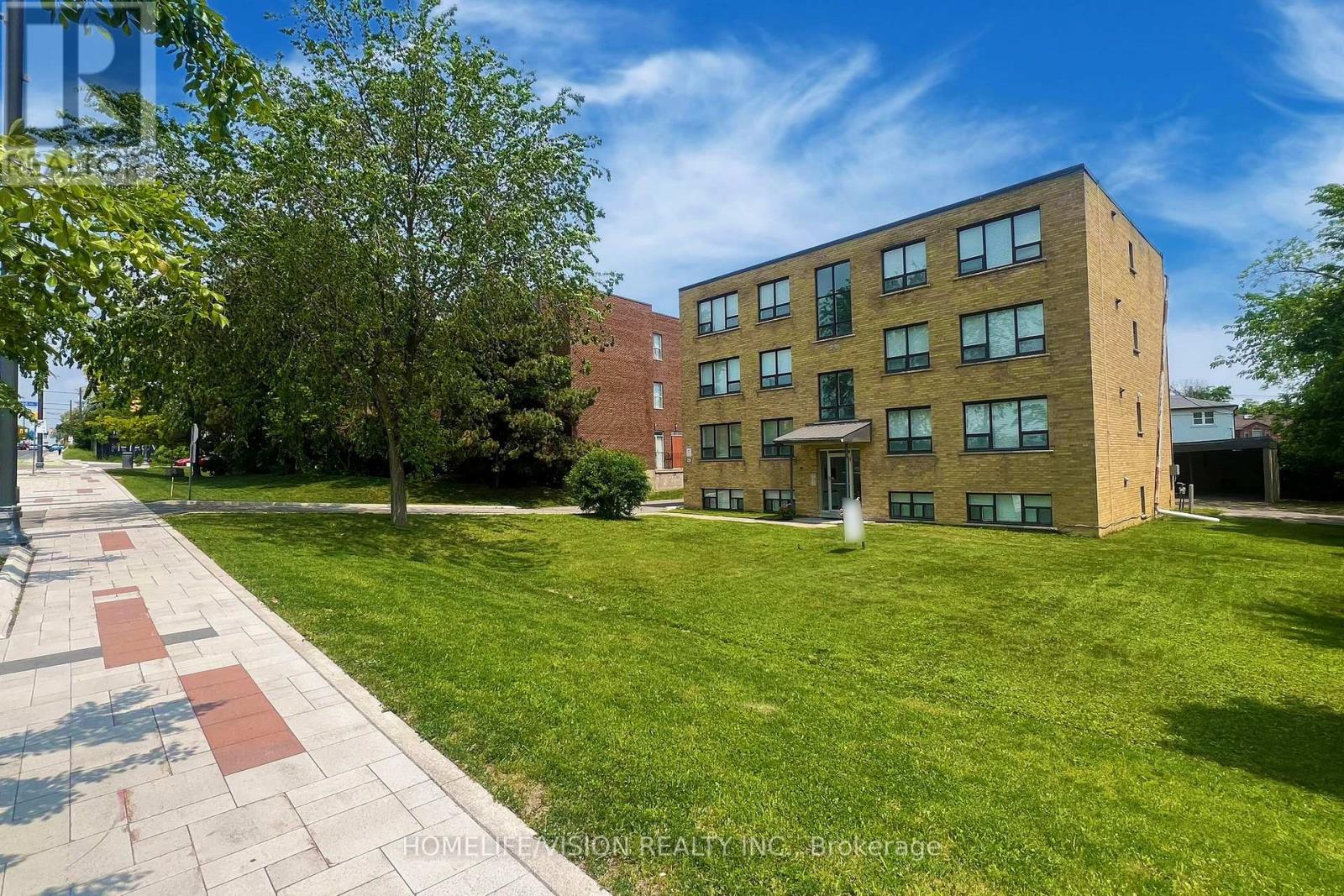 A brick building with a green lawn in front.