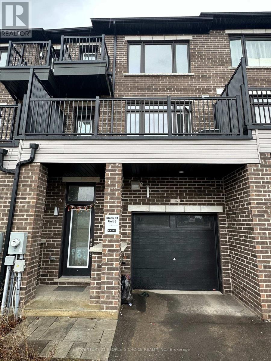 A black garage door is on the right side of a brick building.