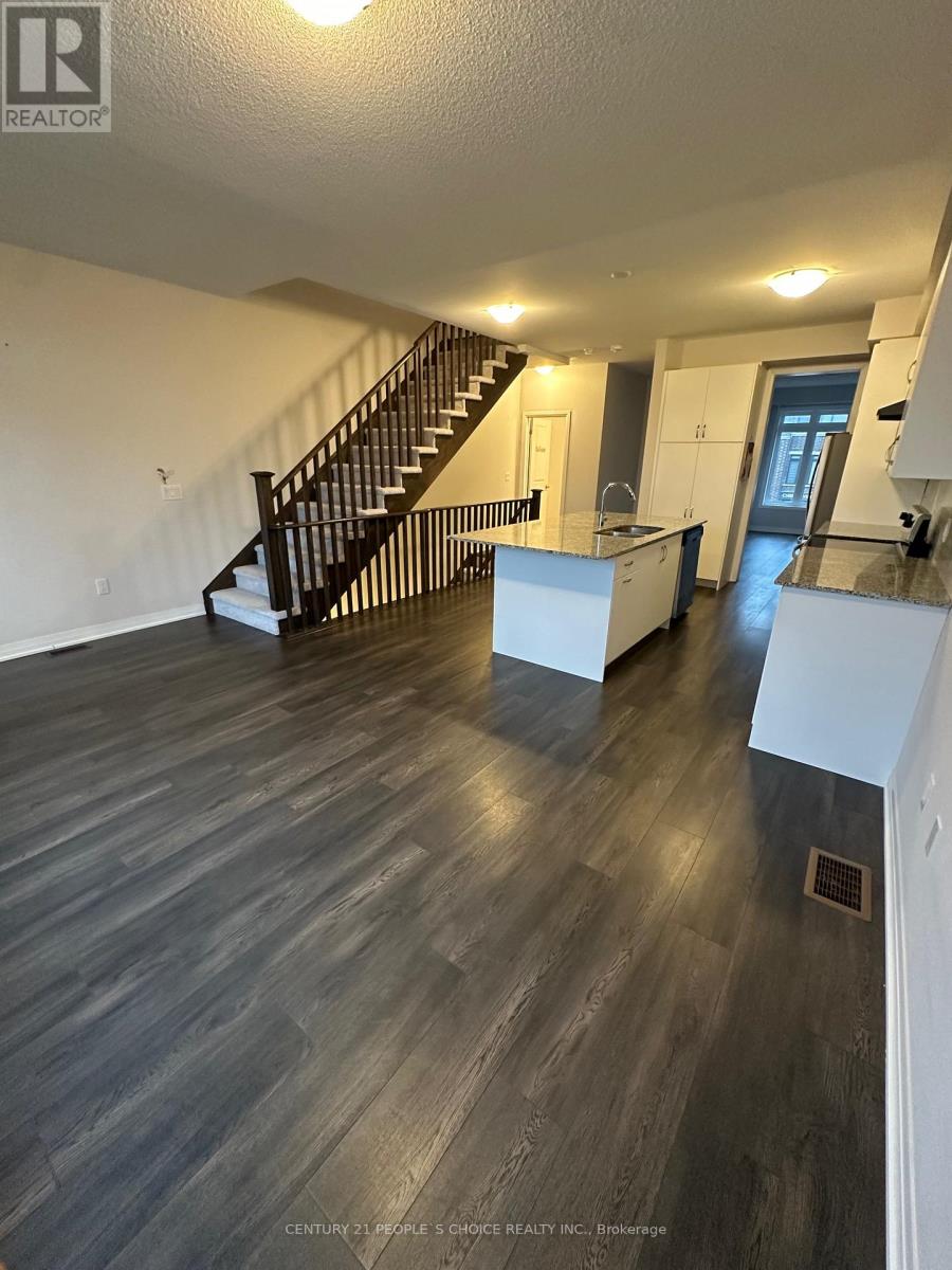A spacious living room with a staircase leading to the upper floor.