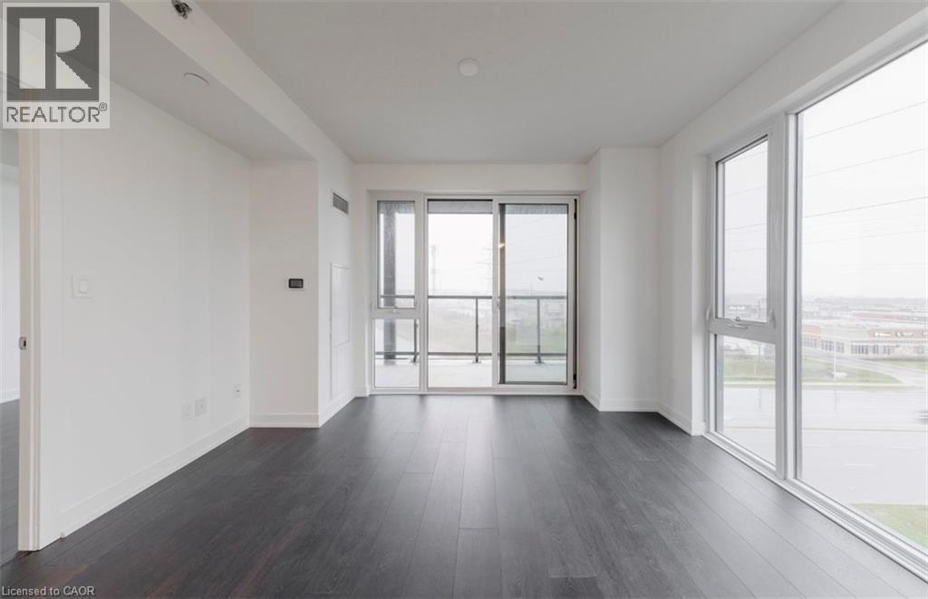 A spacious room with a sliding glass door leading to a balcony.