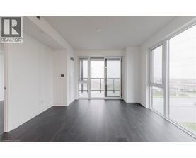 A spacious room with a sliding glass door leading to a balcony.