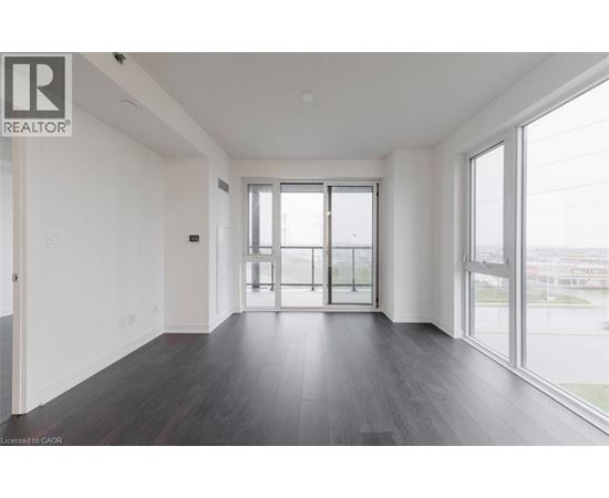 A spacious room with a sliding glass door leading to a balcony.