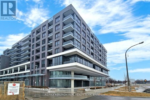 A large, modern building with a glass entrance and a sign that reads RE/MAX REALTRON REALTY TEAM, Brokerage.