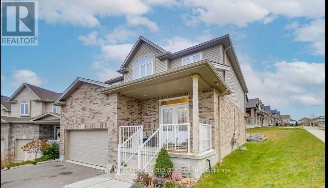 A house with a stone facade and a white garage door is for sale.