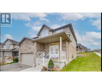 A house with a stone facade and a white garage door is for sale.