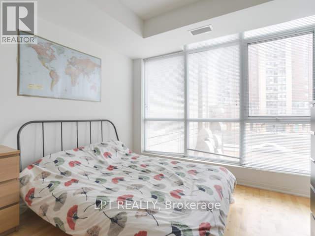 A bedroom with a bed, dresser, and a world map on the wall.