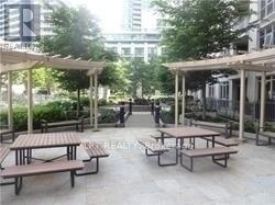 A park with tables and benches under a canopy.