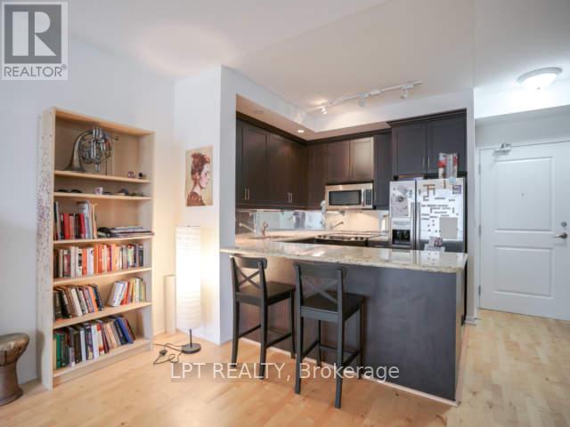 A kitchen with a bar stool and a bookshelf.