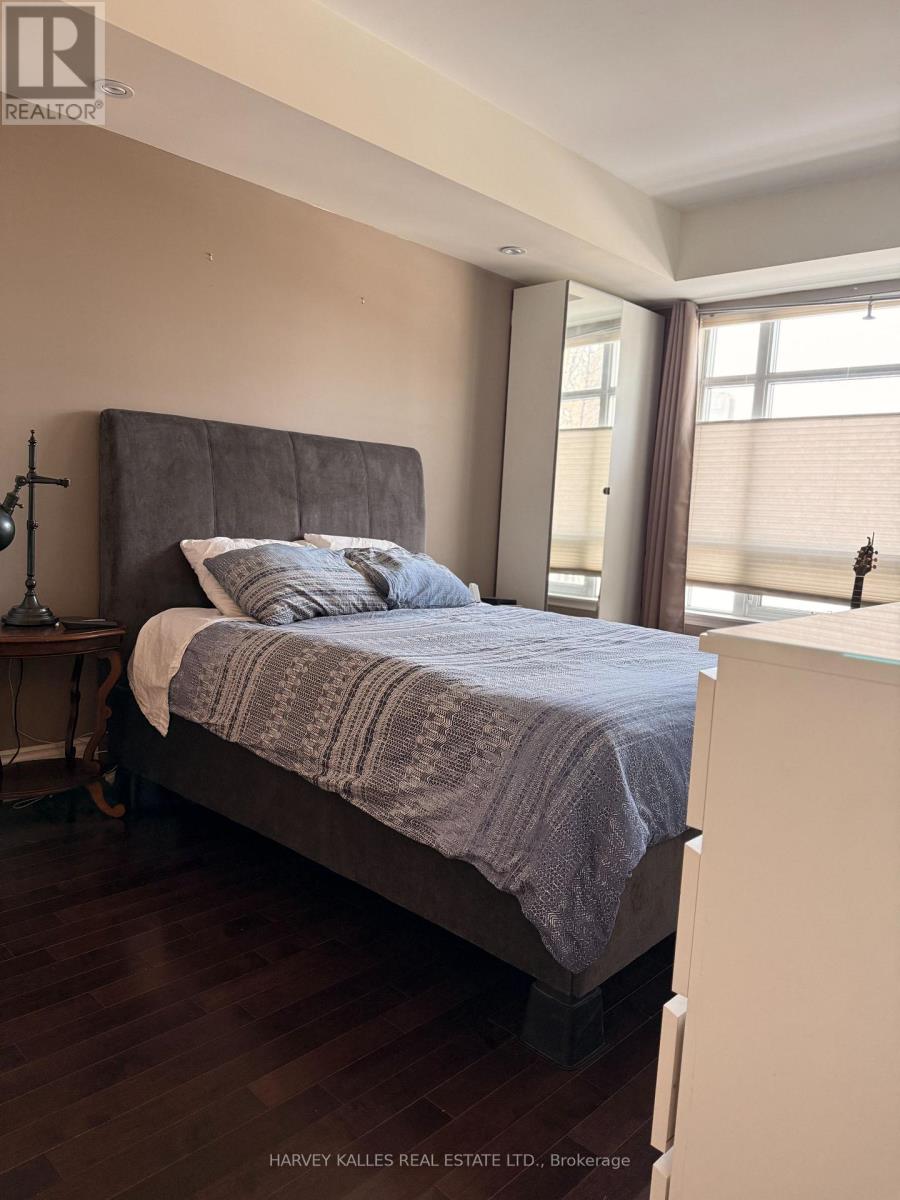 A bedroom with a bed, nightstand, and window.