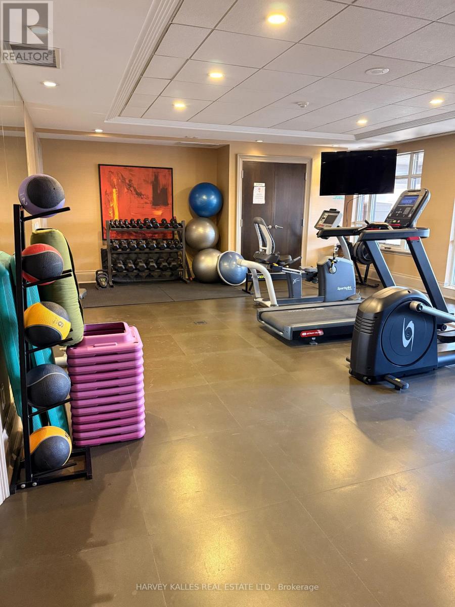A gym with a variety of equipment including a treadmill, exercise balls, and weights.