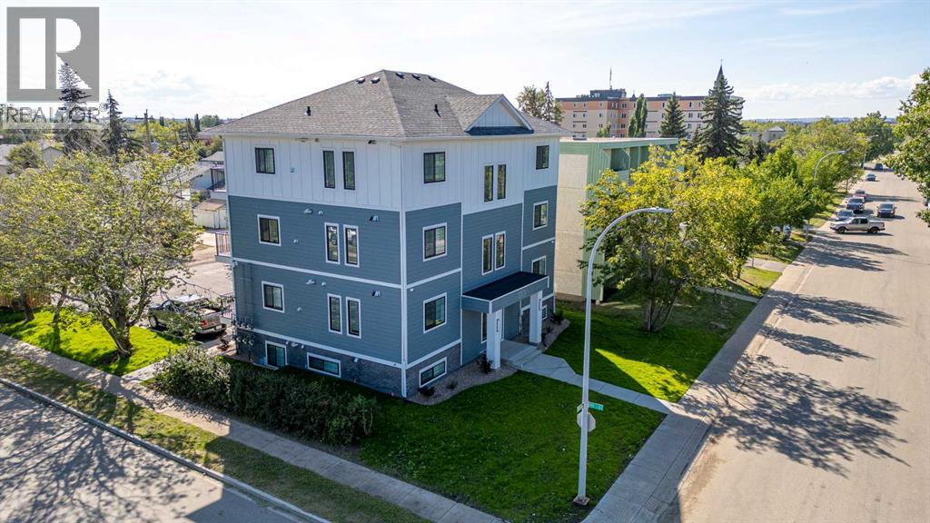 A blue and white two-story house with a green lawn in front.