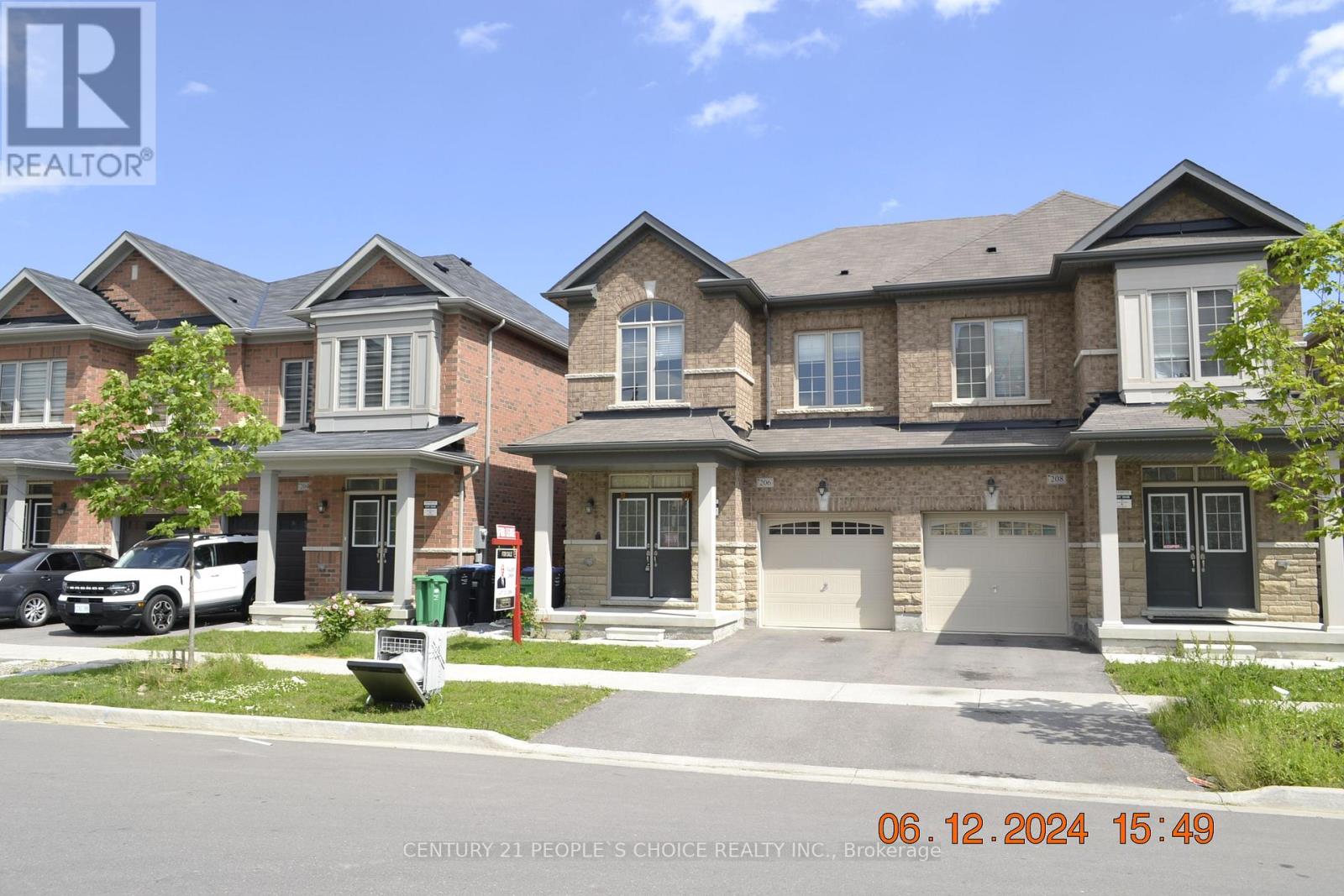 A row of houses with a car parked in front of the first house.