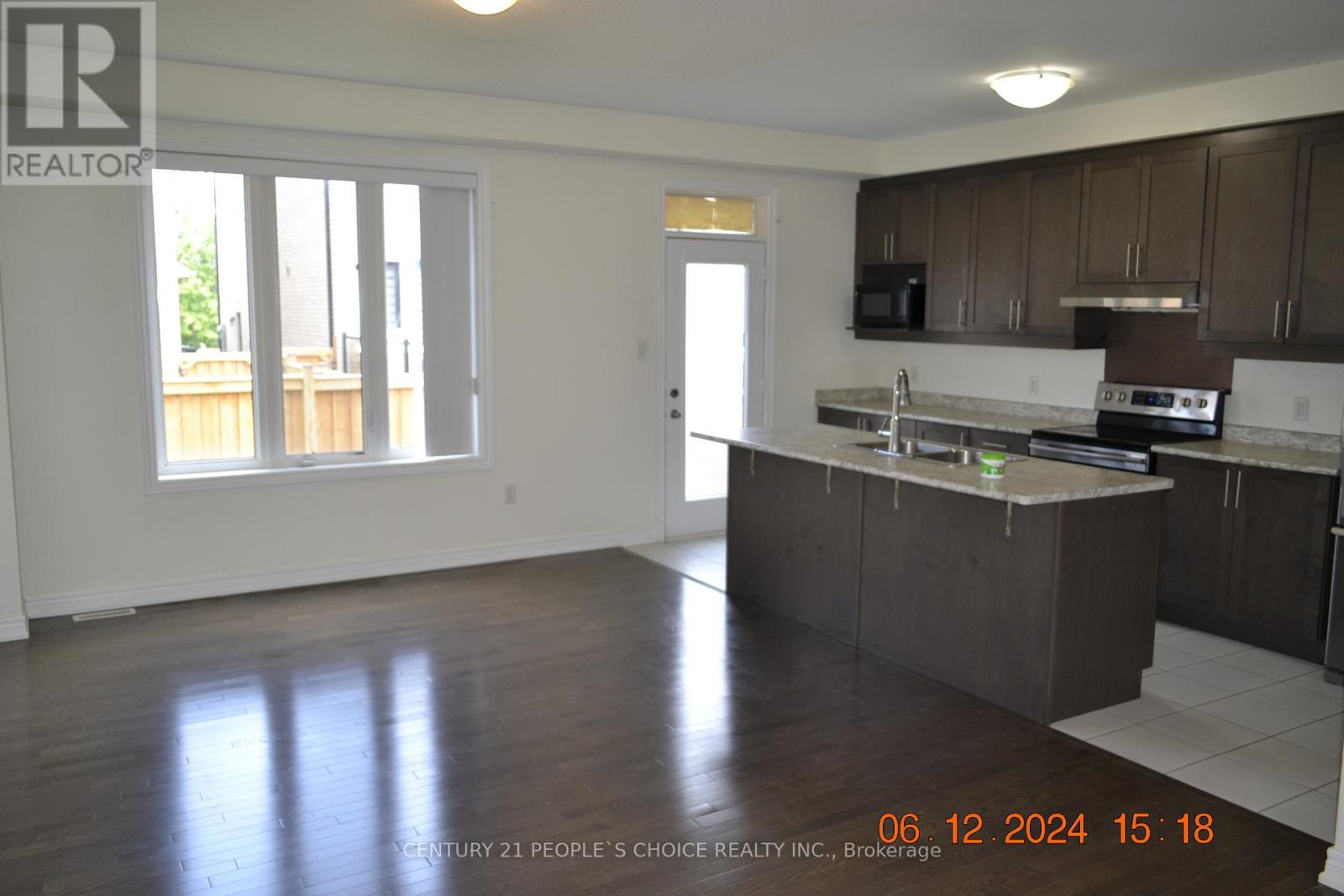 A realtor photo of a kitchen and living room.