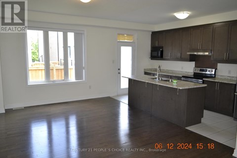 A realtor photo of a kitchen and living room.