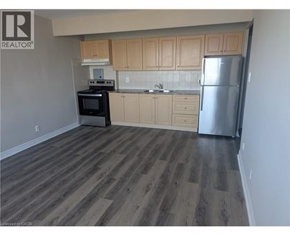 A kitchen with wooden cabinets and a refrigerator.