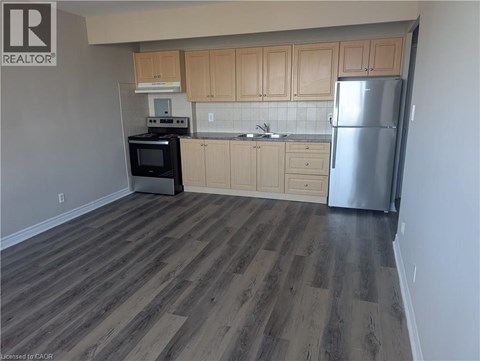 A kitchen with wooden cabinets and a refrigerator.