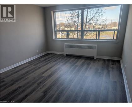 A room with a window and a radiator on the floor.