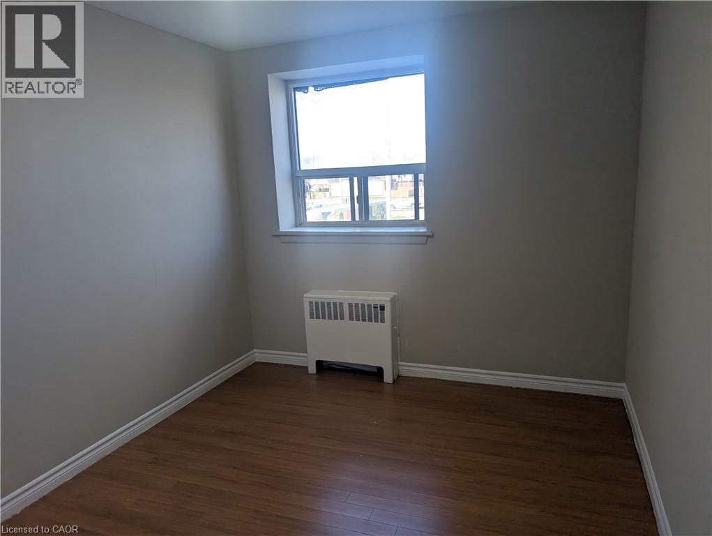 A room with a window and a radiator on the floor.