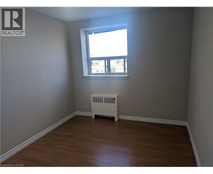 A room with a window and a radiator on the floor.
