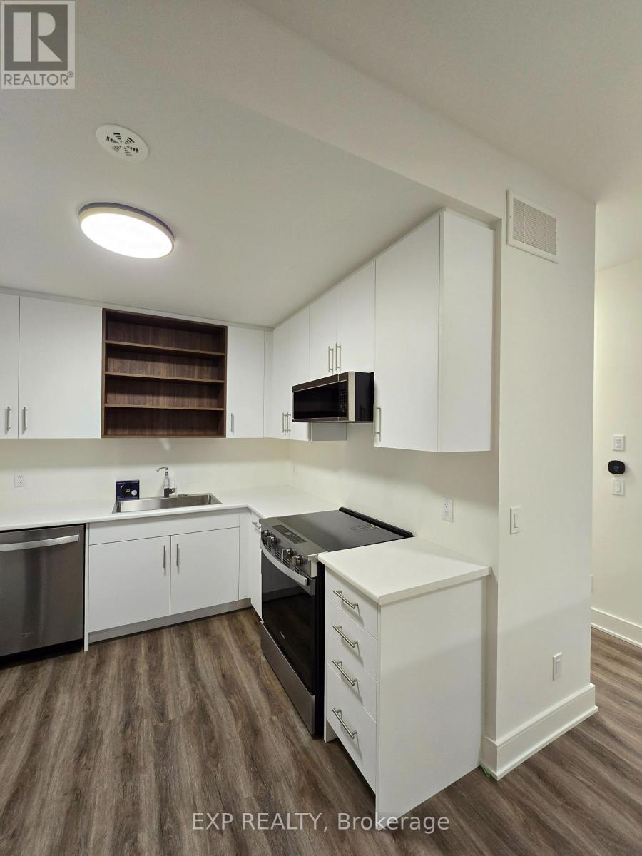A kitchen with white cabinets and a wooden floor.