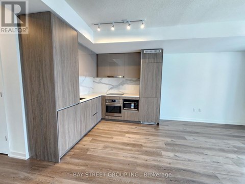 A modern kitchen with wooden cabinets and a marble backsplash.