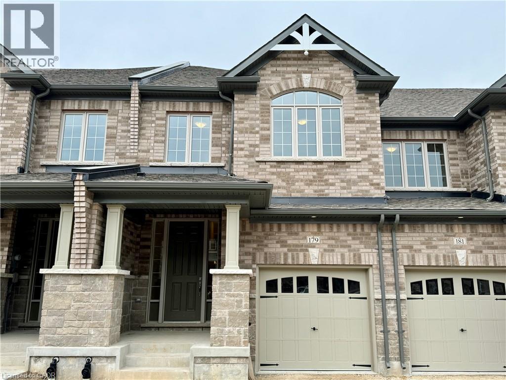 A house with a grey garage door and a stone pillar.