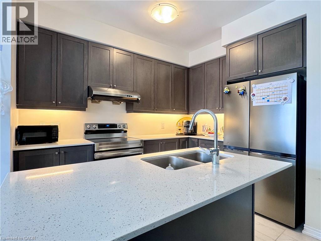 A modern kitchen with dark brown cabinets and stainless steel appliances.