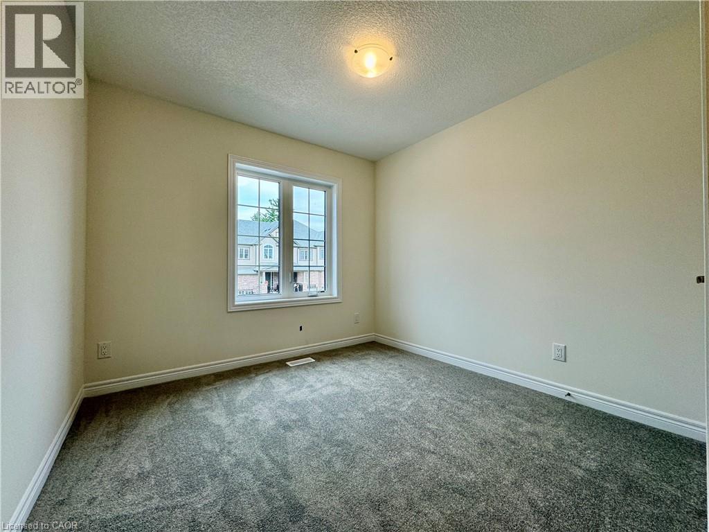 A room with a carpeted floor and a window showing a building outside.