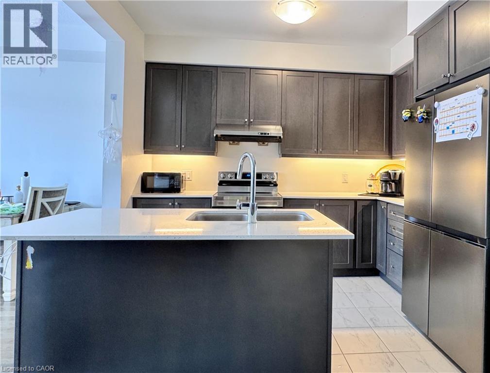 A kitchen with a black counter top and stainless steel appliances.