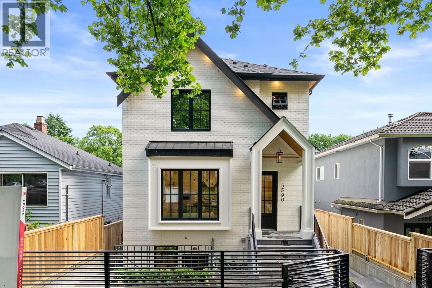 A modern house with a black gate and a white fence.