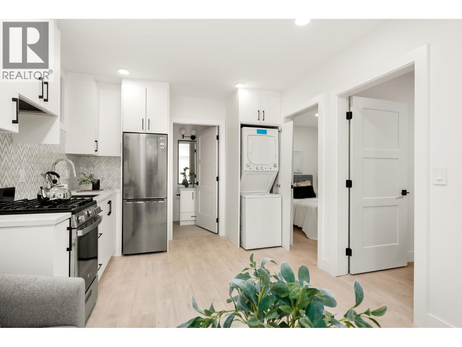 A modern kitchen with white cabinets and a stainless steel refrigerator.
