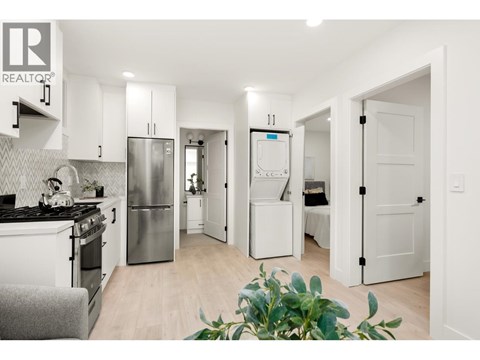 A modern kitchen with white cabinets and a stainless steel refrigerator.