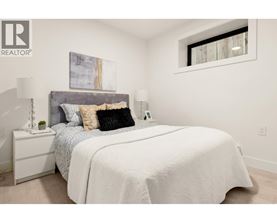 A bedroom with a large bed and a painting on the wall.