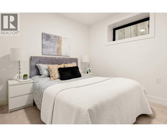 A bedroom with a large bed and a painting on the wall.
