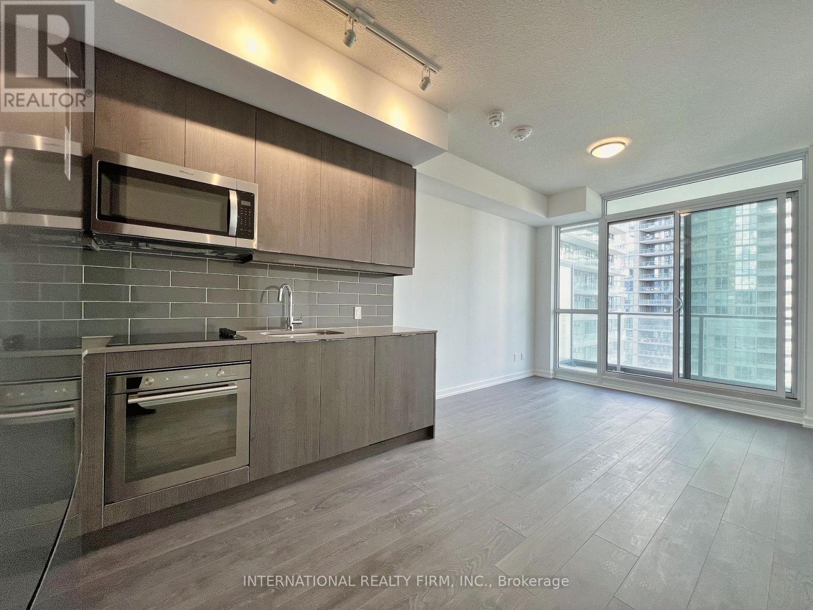 A kitchen with a microwave above the oven and a dishwasher to the left.