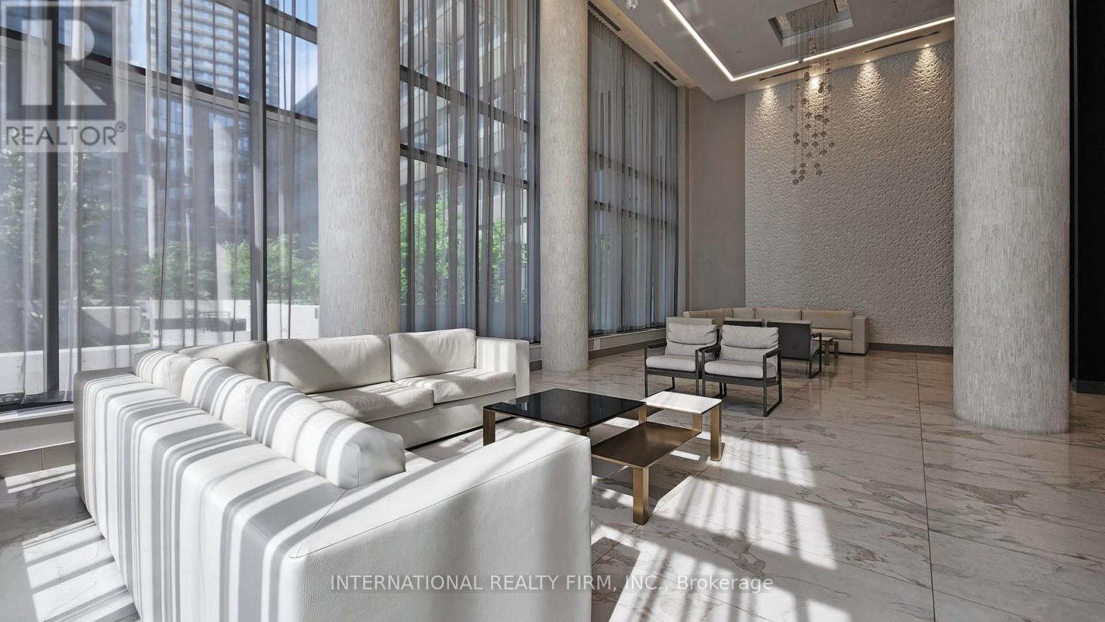 A modern living room with white furniture and large windows.