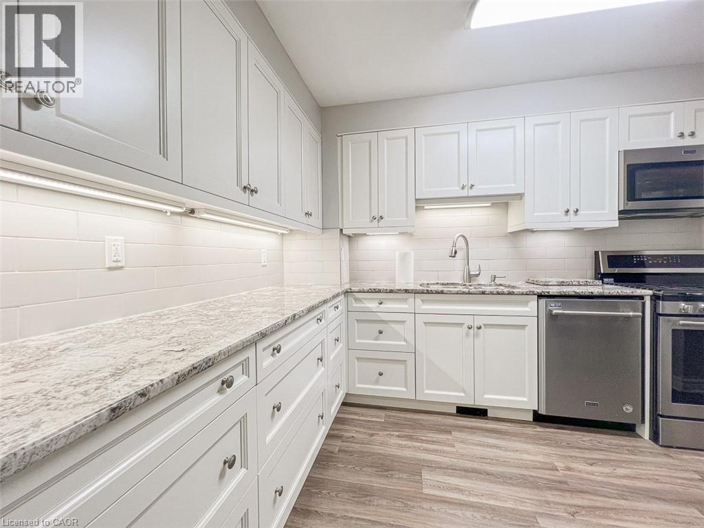 A kitchen with white cabinets and a marble countertop.