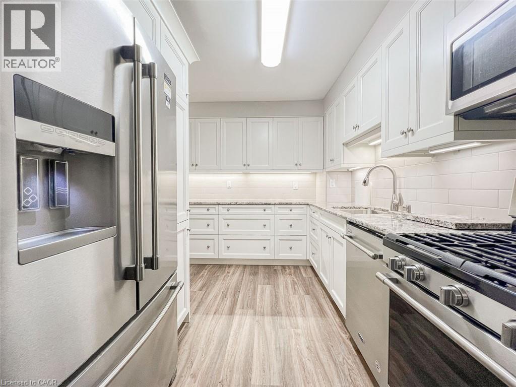 A modern kitchen with white cabinets and stainless steel appliances.