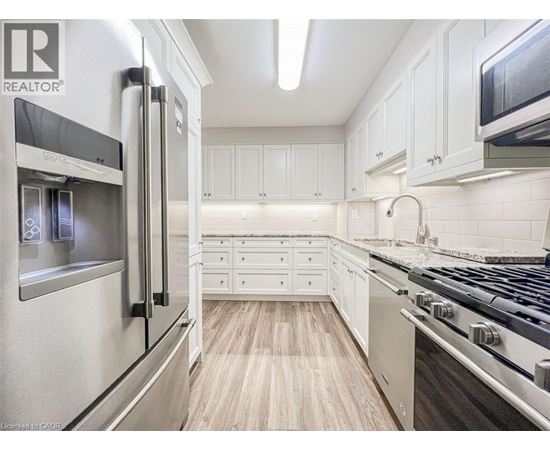A modern kitchen with white cabinets and stainless steel appliances.