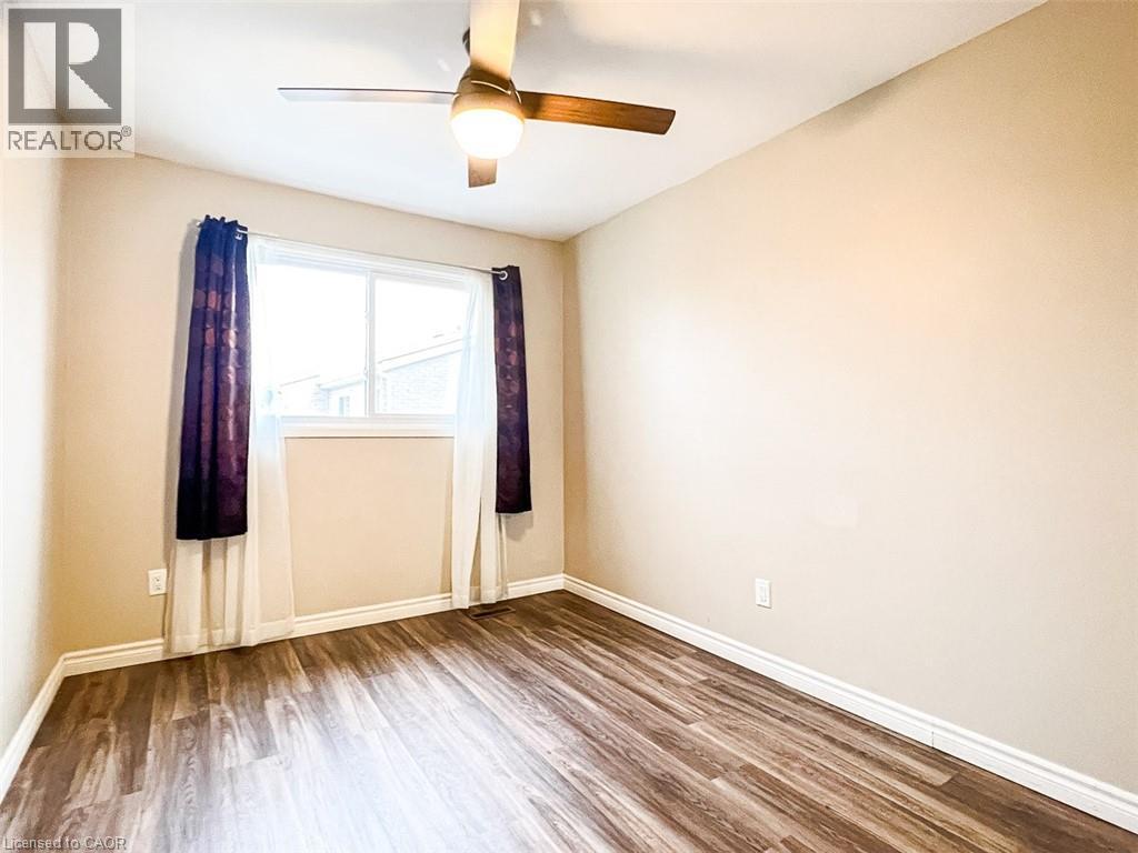 A spacious room with a grey wood floor and white walls.
