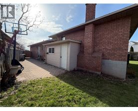 A red brick house with a white garage door and a basketball hoop.
