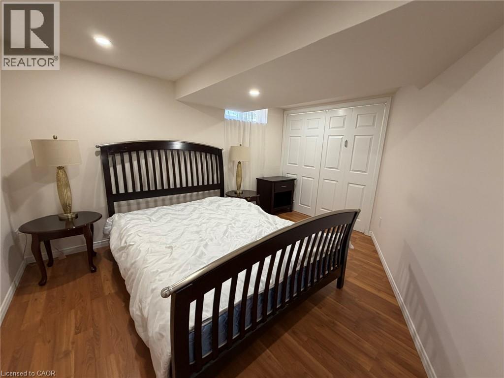 A bedroom with a large bed and a wooden floor.