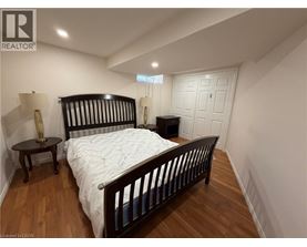 A bedroom with a large bed and a wooden floor.